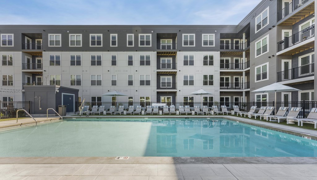 A large swimming pool in front of apartment buildings.
