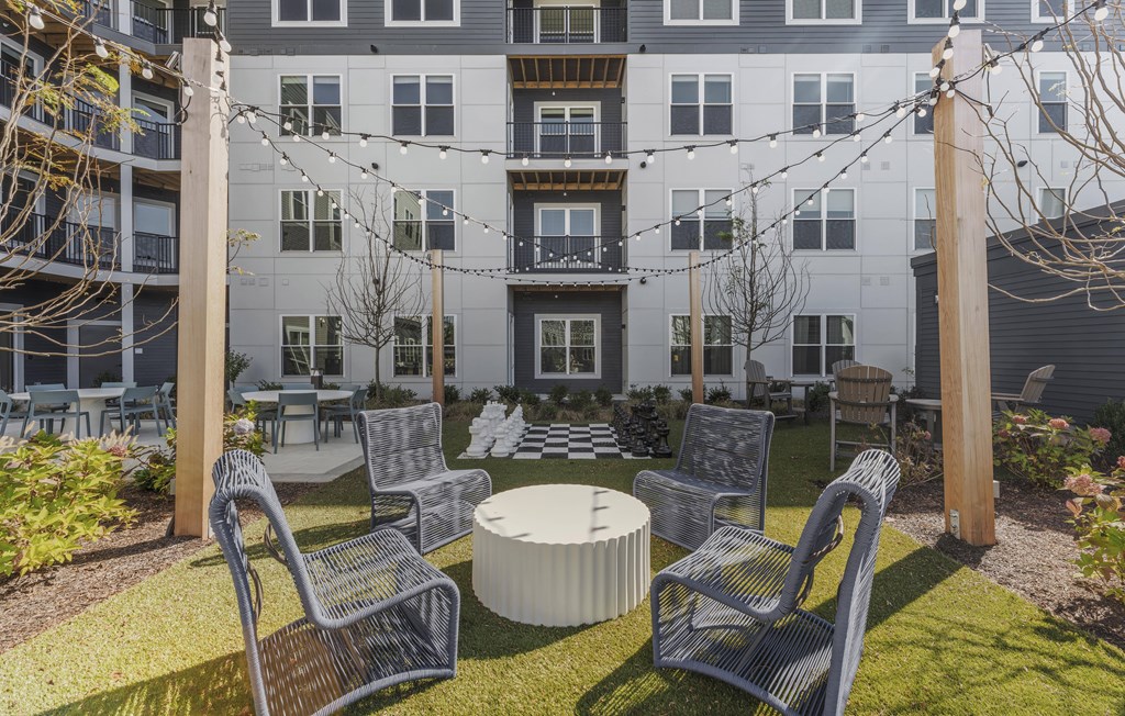 A patio with chairs and a table in front of a building.
