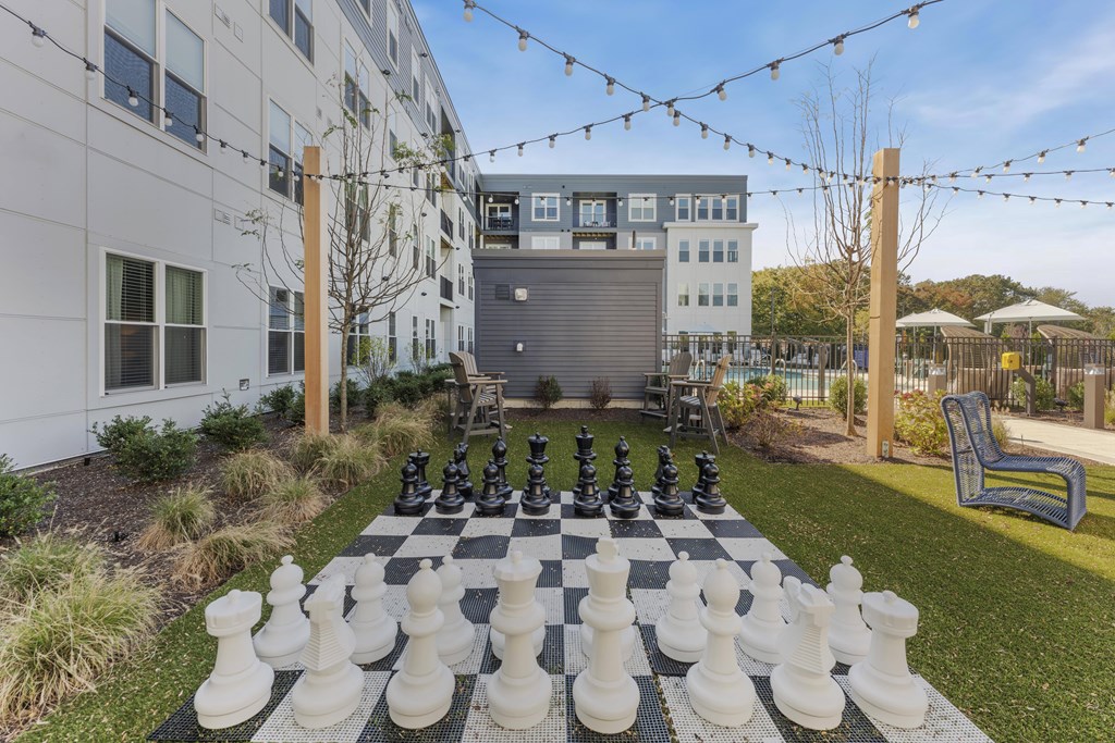 A giant chess board is set up on a lawn.
