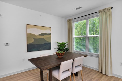 A dining room with a wooden table and chairs.