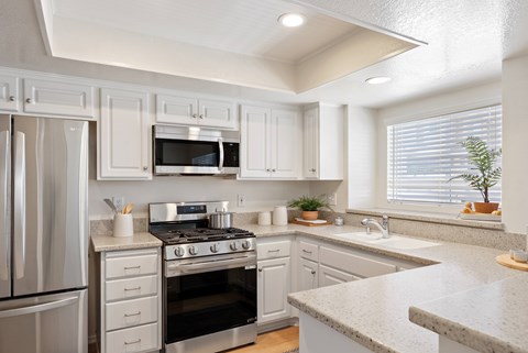 A kitchen with white cabinets and stainless steel appliances.
