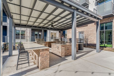 A patio with a table and chairs under a roof.