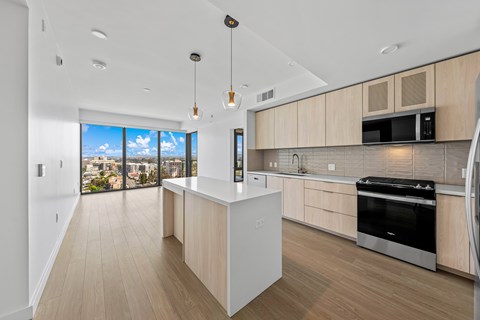A modern kitchen with wooden cabinets and a large island.
