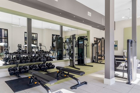 A gym with a variety of equipment including weights and cardio machines.
