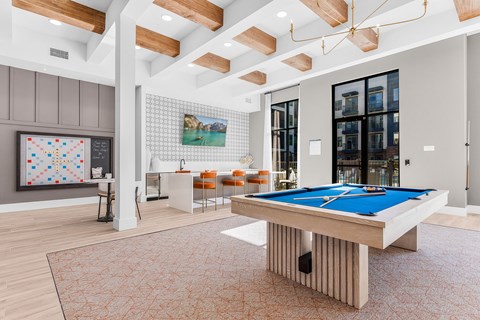 A billiard table is in the middle of a room with a pool table.