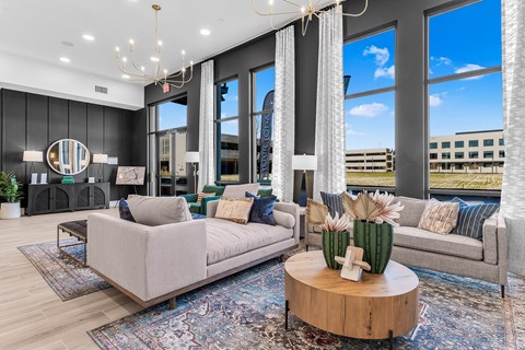 A modern living room with a large window and a view of a building outside.