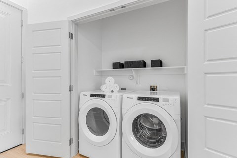 A white laundry room with two washing machines.