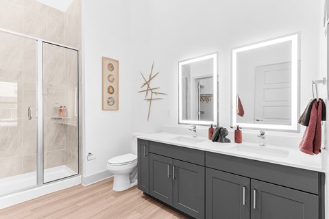 A bathroom with a toilet, sink, and mirror.
