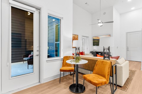 A modern dining room with a glass table and chairs.