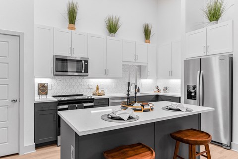 A modern kitchen with a large island and stools.