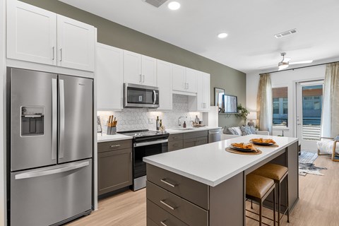 A modern kitchen with a large island and stainless steel appliances.