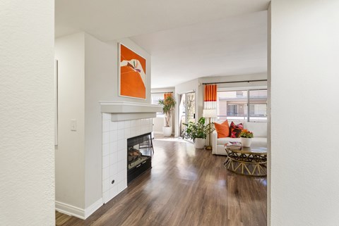 A living room with a fireplace and a painting on the wall.