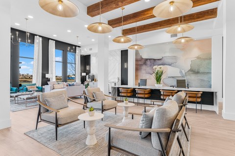 A living room with a grey sofa and wooden chairs.