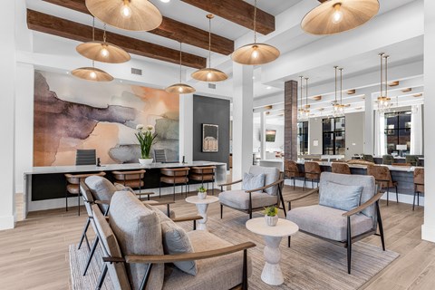 A modern living room with a large painting on the wall and a variety of seating options.