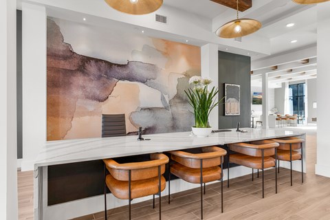 A modern kitchen with a large island and chairs.