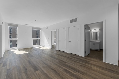 A spacious room with wooden floors and white walls.