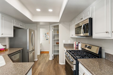 A kitchen with a stove top oven and a refrigerator.