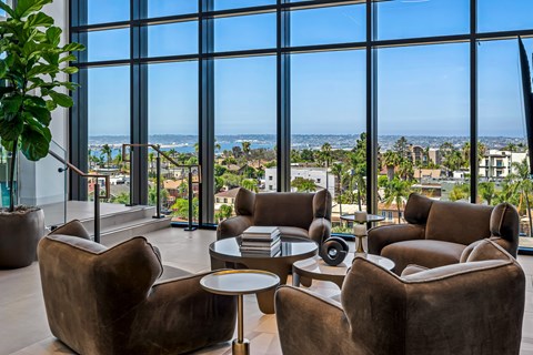 A living room with brown leather chairs and a table with a plant in it.