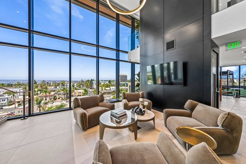 A modern living room with a view of the cityscape outside the large windows.