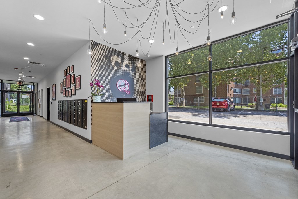 a view of the lobby and front door of a building with large windows and a chandel