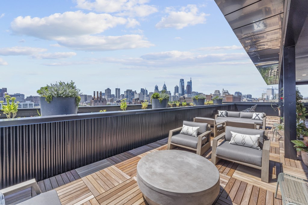 a terrace with a table and chairs with a view of the city in the distance