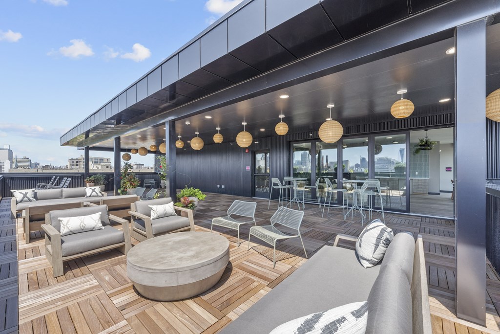a rendering of the rooftop patio of the building with couches chairs and a coffee table