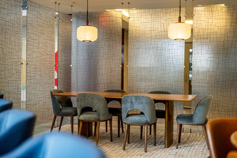A meeting table with blue chairs.