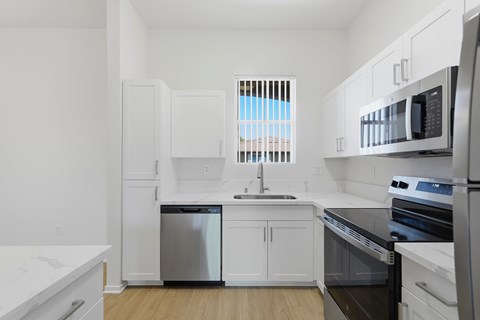 A kitchen with white cabinets and black appliances.