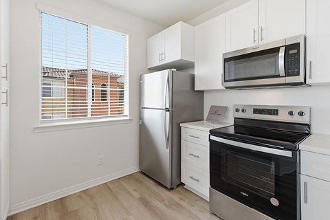 A kitchen with a stainless steel refrigerator, oven, and microwave.