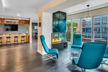 Wood plank style flooring in a living room with blue chairs and a fireplace