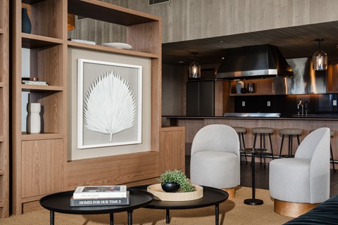 A modern living room with a black coffee table and a framed picture on the wall.