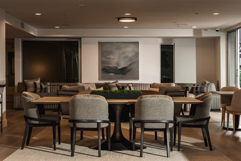 A modern dining room with a large table and chairs.