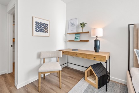 a desk with a chair and a lamp in a living room