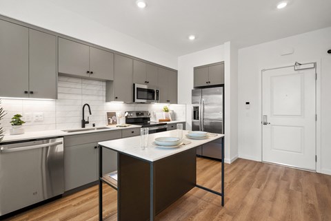 a modern kitchen with stainless steel appliances and a marble counter top
