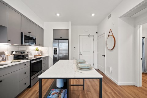 a kitchen with a white marble table and black appliances