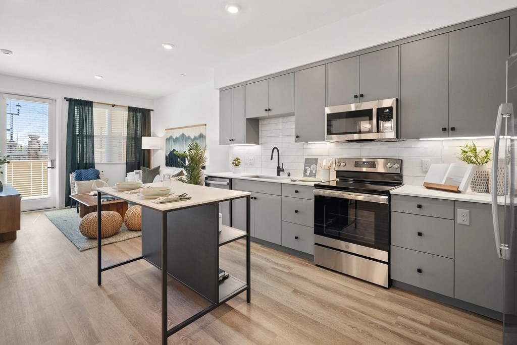 an open kitchen and dining room with stainless steel appliances and a table