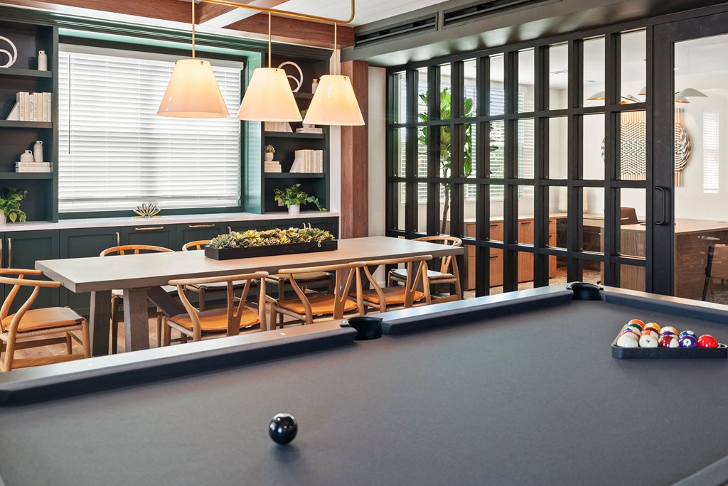 a room with a pool table and a table with balls on it