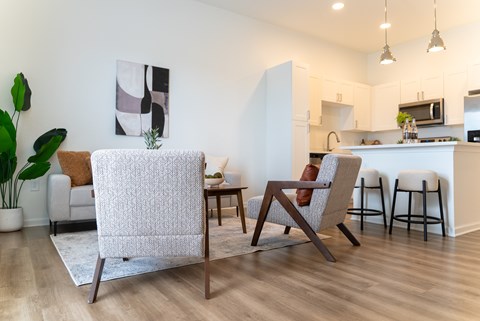 A modern living room with a white chair and a brown couch.