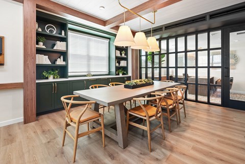a dining room with a table and chairs and green cabinets