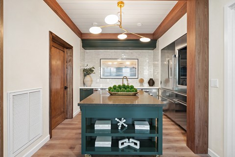 a kitchen with a green island in the middle of it
