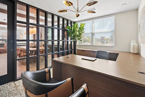 a conference room with a desk and chairs and a large window