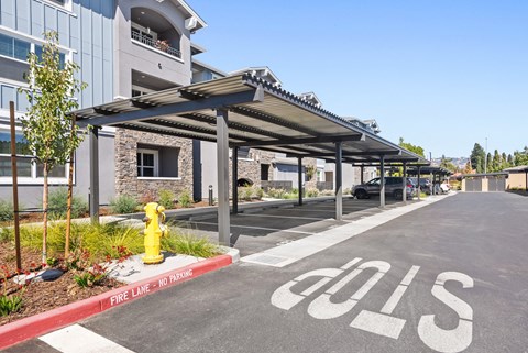 a parking lot with a yellow fire hydrant in front of a building