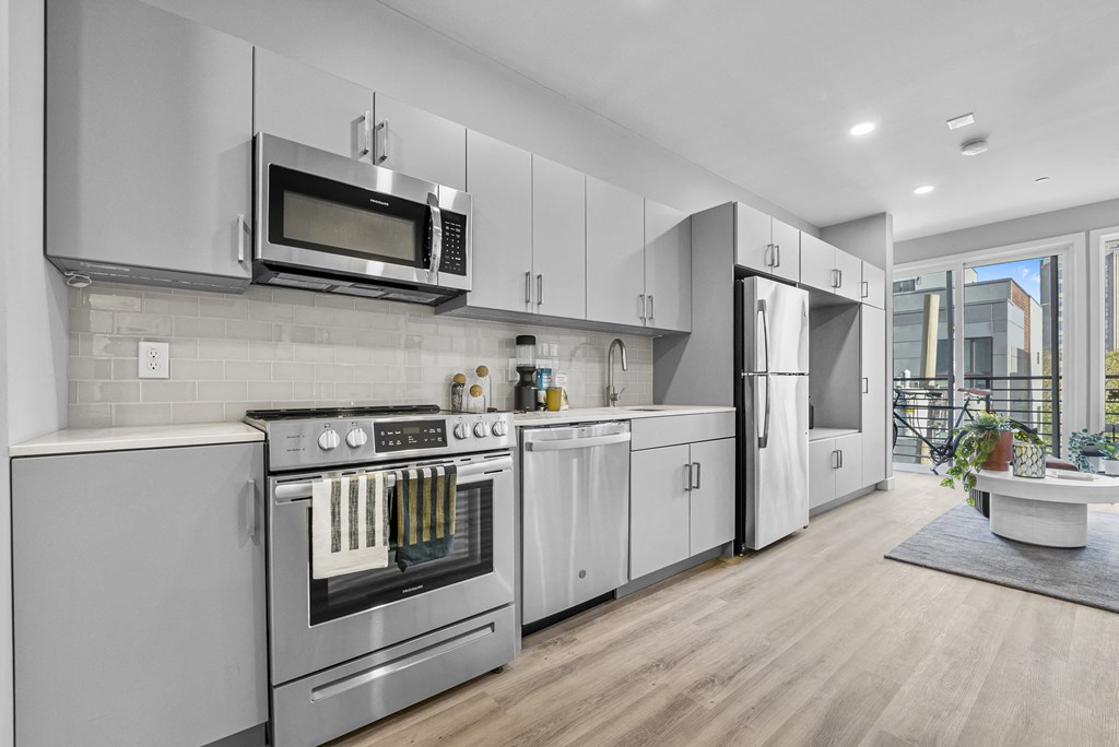 a kitchen with white cabinets and stainless steel appliances