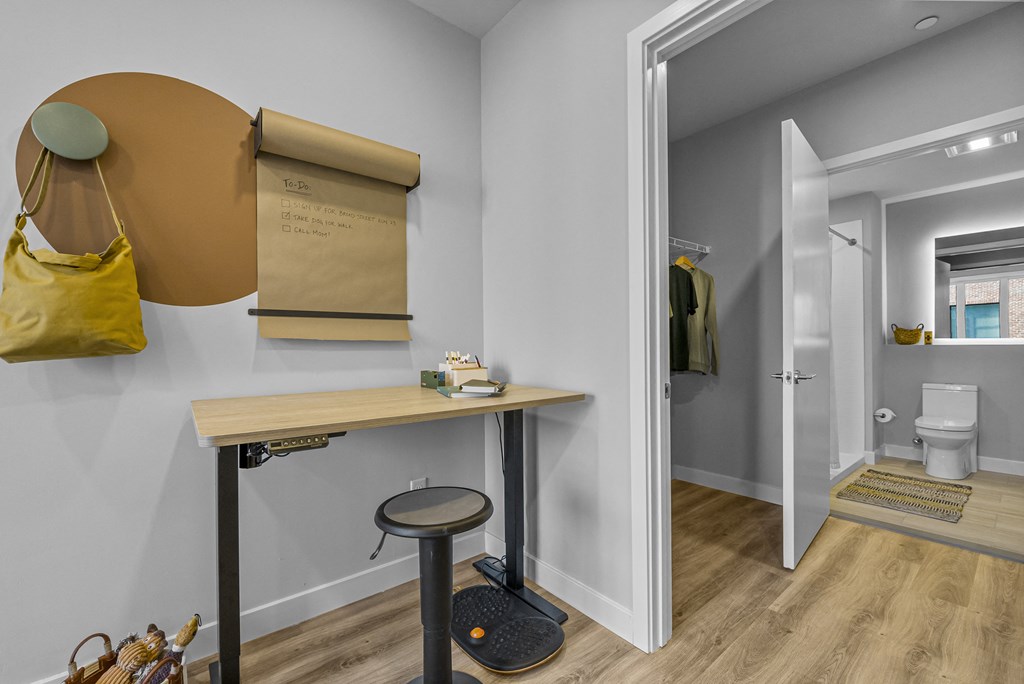 a desk and stool in a room with an open door