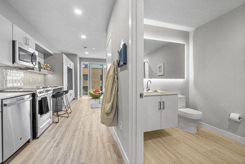 an open kitchen and living room with a sink and a toilet