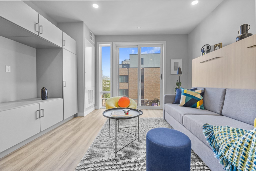 a living room with a grey couch and a yellow and orange chair