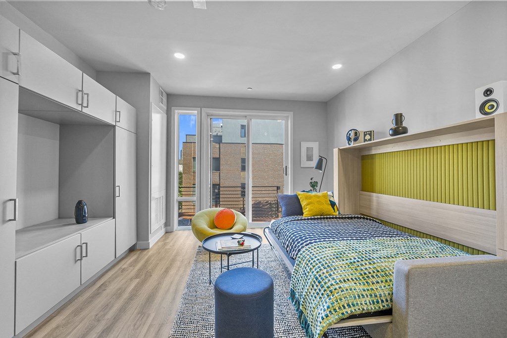 a bedroom with a bunk bed with a yellow headboard and a blue and yellow bedspread
