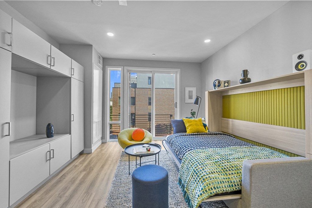 a bedroom with a bunk bed with a yellow headboard and a blue and yellow bedspread