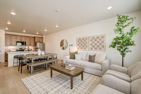 A model living room and kitchen with wood-grain flooring inside a house for rent at Bloom Rental Living in Fort Collins, CO.