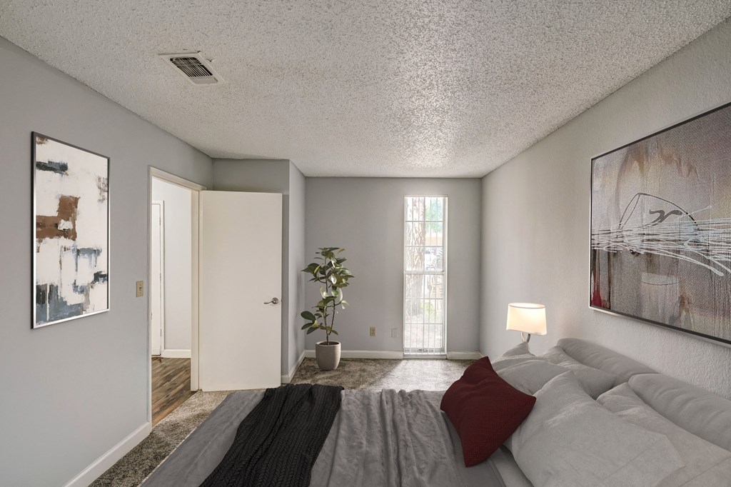 the master bedroom has a large bed and a sliding door to the living room